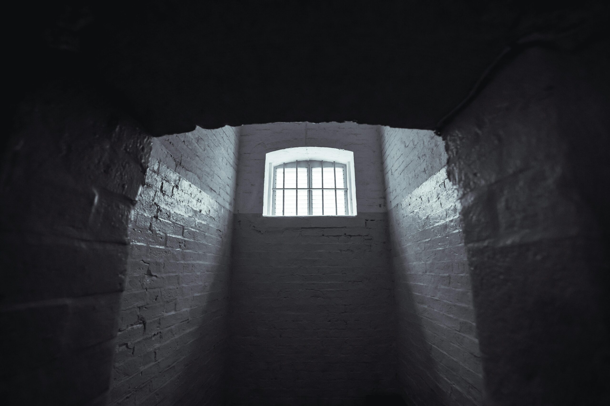 Moody shot of an abandoned prison cell in Hong Kong with dim lighting and shadowy walls.